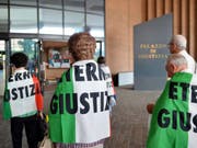 Verwandte von Asbest-Opfern, eingehüllt in italienische Flaggen mit dem Schriftzug "Eternit Giustizia" (zu deutsch etwa: "Gerechtigkeit im Eternit-Fall"), vor dem Turiner Justizpalast. (Archiv) (Bild: Keystone/EPA ANSA/ALESSANDRO DI MARCO)