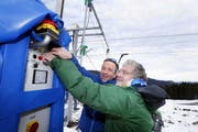 Die beiden Ägerer Pfarrer Urs Stierli (links) und Jürg Rother setzen den Skilift Mega Star mit einem gemeinsamen Knopfdruck erstmals in Gang. (Bild: Werner Schelbert / Neue ZZ)