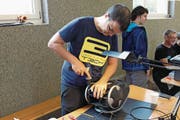 Philipp Hiltbrunner von Hackerspace Uri versucht den defekten Staubsauger mit dem Bohrer zu öffnen. (Bild: Markus Zwyssig (Erstfeld, 9. 9. 17))