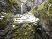 Ein Bergbach beim Eingang des Höllochs im Muotathal. Die eingeschlossene achtköpfige Gruppe muss wohl noch bis am Wochenende ausharren. (Bild: Keystone/URS FLUEELER)