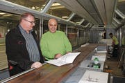 Gerold Ritz von der MGB (links) und Schreiner Damian Deflorin besprechen an der neu installierten Bar im Wageninnern die Pläne für den weiteren Ausbau.