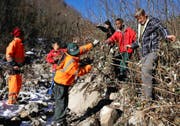 Asylbewerber bekämpfen Neophyten entlang des Steinibachs in Giswil. Instruiert werden sie von Walter Ettlin (hinten mit schwarzer Mütze) und ORS-Betreuer Beat Herger (rechts). (Bild Corinne Glanzmann)