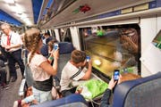Die glücklichen Gewinner geniessen die erste Fahrt durch den neuen Gotthardtunnel. (Bild: EPA/Christian Beutler)