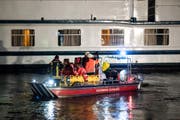 Einsatzkräfte der Feuerwehr wurden am späten Dienstagabend in Duisburg (Nordrhein-Westfalen) mit einem Boot zum havarierten Ausflugsschiff gebracht. (Bild: Marcel Kusch/DPA)