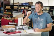 Tobias Schwarzentruber begutachtet vorsichtig eine der Briefmarken, die er in seinem Laden verkauft. (Bild: Philipp Schmidli (Sursee, 7. Dezember 2017))