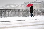 Eine Person, die sich mit einem Schirm vor dem Schnee schützt. (Symbolbild) (Bild: Laurent Gillieron / Keystone (Lausanne, 1. März 2018))