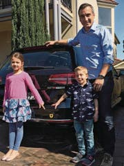 Marco Stampfli mit seiner Tochter Lena und Sohn Liam vor seinem Auto mit Uristier, mit dem er auch in Australien auf seine Wurzeln aufmerksam macht. (Bild: PD (Sydney, 27. August 2017))