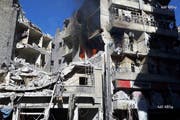Feuer und Rauch steigen aus einem zerbombten Gebäude iim Gebiet Al-Shaar in Aleppo auf. (Bild: Keystone)