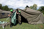 Angehörige der Armee stellen Zelte zur vorübergehenden Unterbringung von Flüchtlingen in Lyss auf. (Bild: Keystone / Peter Schneider)