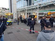 Die Polizei sichert den Tatort: Das schwarze Auto fuhr in eine Menschengruppe und verletzte dabei drei Personen, der Fahrer wurde später angeschossen. (Bild: KEYSTONE/AP PR-Video/dpa/R. PRIEBE)