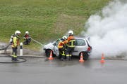 Bei einem gestellten Verkehrsunfall muss der Fahrer gerettet und der brennende Motor gelöscht werden. (Bilder: Sabine Schmid)