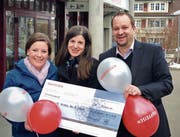 Bankleitungsmitglied Benjie Egloff bei der Checkübergabe an Marianne Wright und Désirée Bachofen vom OK-Team der Kinderfasnacht Nesslau-Neu St. Johann. (Bild: PD)