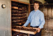 Türe auf, «Schublade» raus: Dörrmeister Thomas Oeler zieht eine Hurde voller Dörrbirnen aus seinem alten Holzofen. (Bild: Luca Linder)