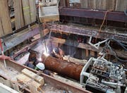Zwei Elemente des Stahlrohres werden zusammengeschweisst. Rechts die Presse, die die Rohre dann nach links in den Untergrund drücken wird. Die Rohre besorgen die Entwässerung des Tunnels Bahnhof.