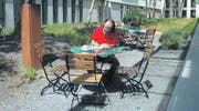 In Gedanken versunken sitzt Lebenskünstler Mark Riklin im Innenhof des Lagerhauses und hält in seinem Logbuch neue Ideen fest. (Bild: bra)