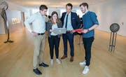 Maurin Büche, Anina Angehrn und Dimitri Sonderegger mit Bankleiter Aldo Kopp in der Raiffeisen-Filiale Niederuzwil. (Bild: PD)