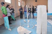 Führung im 80er-Jahre Turndress: Viola Pfeiffer (links) und Maura Kressig (Mitte) von Arthur Junior diskutieren mit einer Schülergruppe über «Fragmente kleiner Welten» von Sonja Lippuner, die Abdrücke von Turngeräten mit Seidenpapier, Leim und Kleister hergestellt hat. (Bilder: Hansruedi Kugler)