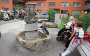 Marina und Silvan bestückten mit Hilfe ihrer Urgrossmutter Hanni Brunner den Brunnen mit Bällen. (Bild: Cecilia Hess-Lombriser)