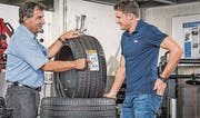 Dario Cologna lässt sich von Martin Inderwildi in der Parkgarage die Vorzüge von energiesparenden Leichtlaufreifen erklären. (Bild: pd)