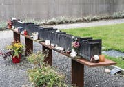 Serie Gutes Bauen in der Ostschweiz: Die Kunstweke auf den Gemeinschaftsgräbern suchen Symbolhaftigkeit, Gemeinchaftlichkeit und Gedenken zu verbinden. Ganz neu auf dem Friedhof Bruggen sind es die in Bronze gegossenen liegenden Baustämme mit eingravierten Namen wie in Holz geritzt, auf dem Friedhof St. Georgen in einander verkeilte Aeste aus Bronze. Beides Werke der Landschaftarchitektin Rita Mettler aus Gossau ujnd der Künstlerin Kaja Terpinska aus Berlin. Auf dem Friedhof in Speicher AR sind es die 'Sechsmetererinnerungen' als 180 Bücher aufgereiht. Die mit den Namer der Toten beschrifteten Büchrücken stehen für die individuellen Biografien. Dieses Werk stammt von dem Künstler Jan Kaeser aus dem Jahr 2005. (Bild: Hanspeter Schiess)