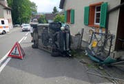 Das Auto kollidierte mit einem Gartenhag, einem Eisentor und einem Holzpfahl und kam auf der Seite liegend zum Stillstand. (Bild: KAPO)