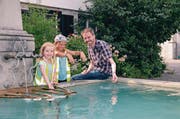 Viviane Keel (links) und Anouk Bucher kommen auf Michael Kontzen zu und planschen mit ihm im Dorfbrunnen. (Bild: Monika von der Linden)