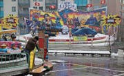 Kampf gegen das Wetter: Betreiber am Frühlingsjahrmarkt befreien ihre Bahnen vom Schnee. (Bild: Christoph Renn)