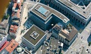 Das Bleicheli im Frühherbst 2005: Die beiden Neubauten der Raiffeisen-Gruppe stehen, jetzt wird an der Strassengestaltung gearbeitet. Am linken untern Bildrand lässt ein roter Fleck erahnen, was geplant ist. (Archivbild: Philipp Baer)