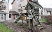 Der Sandkasten ist mit einer Blache abgedeckt, der Spielturm verwaist. Nach dem Umzug des Kindergartens ins Primarschulhaus Brühlacker sind der Spielplatz und die beiden über einen Durchgang verbundenen Wohnungen an der Sandackerstrasse verwaist. (Bild: Andrea Häusler)