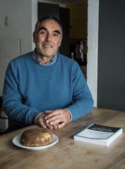 Andreas Koller in seinem Haus in Engelburg. Vor ihm liegen ein Stück roher Zucker und der Friedensvertrag zwischen der kolumbianischen Regierung und den FARC-Rebellen. (Bild: Sabrina Stübi)