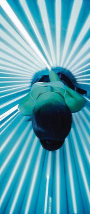 Eine Frau bräunt sich im Solarium. (Bild: Igor Mojzes/Fotolia)