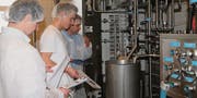 Unter den gestrengen Blicken der beiden Experten nimmt Silas Käser aus Wigoltingen, Milchtechnologe im dritten Lehrjahr, die Schau-Pasteurisierungsanlage im «Mattenhof» in Betrieb. (Bild: Andrea Häusler)