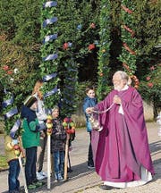 Pfarrer Georg Schmucki segnet die Palmen aus den Dörfern. (Bild: Cecilia Hess-Lombriser)