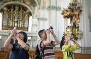 Familie Li fotografiert in der Kathedrale. Touristen aus China machen 1,5 Prozent der Logiernächte in der Stadt St. Gallen aus – Tendenz steigend. (Bild: Coralie Wenger (25. Juli 2014))