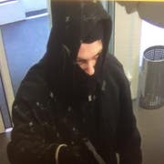 Maskiert und bewaffnet betrat der Mann die Bank in Wittenbach. (Bild: Kapo SG)
