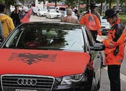 Nicht toleriert: Die grosse Fahne im Autodach (oben) und die Flagge auf der Motorhaube gefährden gemäss Polizei die Verkehrssicherheit.