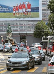 Euphorie in Rot-Weiss: Schweizer Fans am Samstag zu Fuss vor der «Union» sowie im Auto mit Werbeplakat einer Bank und Stadtbus auf dem Oberen Graben. (Bilder: Reto Voneschen)