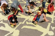 Sonnig ist es geworden: Die Fünftklässler des Schulhauses Riethüsli mit Pinsel und Farbeimern bei der Verschönerung ihres Pausenplatzes. (Bild: Coralie Wenger)