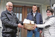 Ortspräsident Guido Seitz (links) übergibt die durch die Schulsekretärin nach Schulklasse abgepackten Jetons an Schulleiter Remo Ganther und Co-Schulleiterin Bernadette Müller. (Bild: pd)