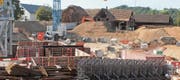 Im Hintergrund wird die alte Scheune abgebrochen, im Vordergrund werden bereits die Fundamente für die Neubauten erstellt. (Bild: Andrea Häusler)