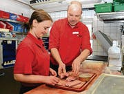 Werner Küttel zeigt Laura Dürr die richtige Technik, mit der ein Metzger das Rohmaterial veredelt. Hier entstehen Cordon bleus. (Bild: Monika von der Linden)