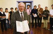 Frank Jehle mit dem von ihm neu herausgegebenen Kirchengesangbuch von 1533; um ihn der Chor der Kirchenmusikschule St. Gallen (Bild: Urs Jaudas)