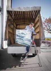 Joachim Gugger transportiert eines seiner rund 50 Bilder hinunter in die Kellergalerie. (Bild: Benjamin Manser)