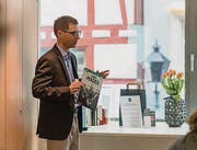 Claudius Krucker von Buchstadt St. Gallen zeigt einen Comic aus der Bibliothek, die hinter ihm in der Plexiglasbox zu sehen ist. (Bild: Kathrin Reimann)