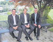 Banker sitzen bequem auf der gesponserten Bank im Augarten: Adrian Müller, Vorsitzender Geschäftsleitung Clientis Bank (rechts), sowie die Kundenberater Philipp Müggler (Mitte) und Anian Willi. (Bild: Bea Näf)