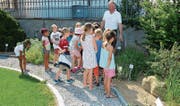 Pastoralassistent Jürgen Kaesler erklärt den Zweitklässlern die Bedeutung der Pflanzen.