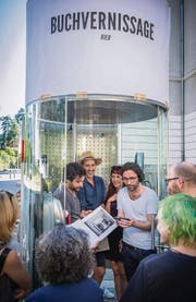 Claudio Bäggli (mit Hut), Soraia Simao, die Riklins und Gäste hören der Laudatio aus dem Mobiltelefon zu. (Bild: Urs Bucher)