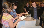 Zwei junge Asylbewerberinnen aus Sri Lanka bewirten die Bürgerinnen und Bürger beim Apéro mit Weisswürsten. (Bild: Urs Bänziger)