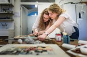 Zwei Schülerinnen des Freifachs «Humanitäres Völkerrecht» bedrucken Jutebeutel, die sie beim Benefiz am Samstag verkaufen möchten. (Bild: Michel Canonica)
