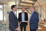 Gemeindepräsident Roman Habrik nimmt die Unterschriftenbögen von Damian Kalbermatter und Thomas Feller entgegen (von links). (Bild: Beat Lanzendorfer)